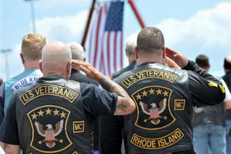 Members of the U.S. Veterans Motorcycle Club salute the flag during the playing of the National Anthem at the beginning of a memorial and remembrance service for seven motorcyclists and their spouses who died in the June crash Saturday, July 13, 2019 in the parking lot of Gillette Stadium in Foxboro, Mass. The seven bikers were killed when a pickup truck hauling a flatbed trailer slammed into a group of riders in Randolph, New Hampshire. (Mark Stockwell/The Sun Chronicle via AP)