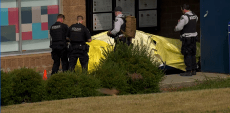 Police officers surround a car that's covered in tarps following the fatal shooting of Suminder "Allie" Grewal in Surrey, B.C. on Aug. 2, 2019.